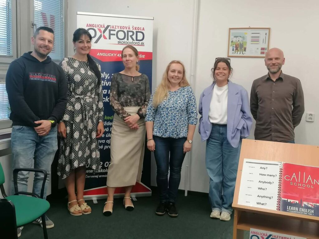 Šesť študentov a lektor stoja v učebni jazykovej školy Oxford v Martine